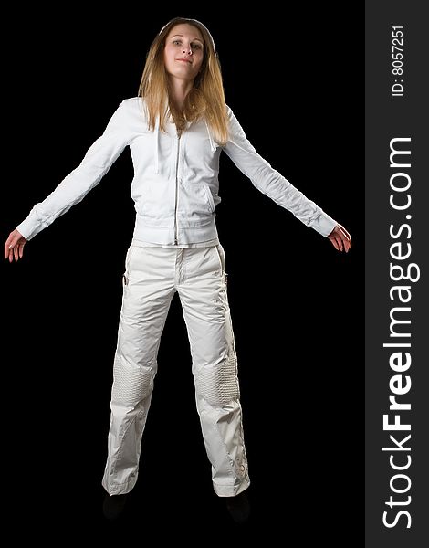 Woman in a white sports suit jumps on a black background
