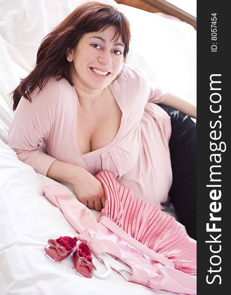 Young beautiful pregnant woman with small pink dress. Young beautiful pregnant woman with small pink dress