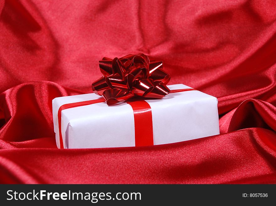 Red gift box on red satin background