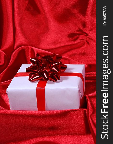 Red gift box on red satin background