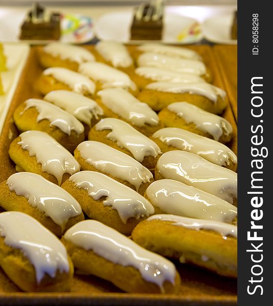 Fresh delicious cream filled pastries at a market or buffet iced with vanilla. Fresh delicious cream filled pastries at a market or buffet iced with vanilla