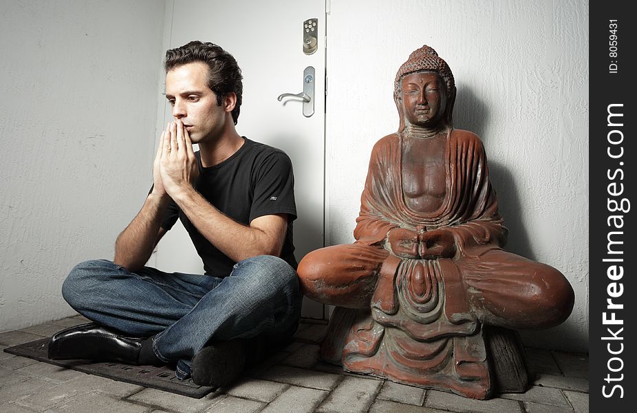 Man sitting next to a Buddha. Man sitting next to a Buddha
