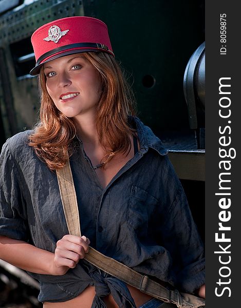 Young woman wearing red cap in front of locomotive