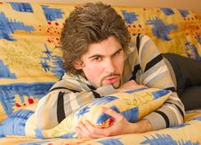 Young Serious Handsome Male On Colourful Sofa Stock Photo