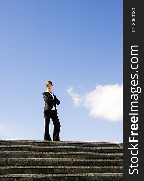 Businesswoman posing against huge cloudscape. Businesswoman posing against huge cloudscape.