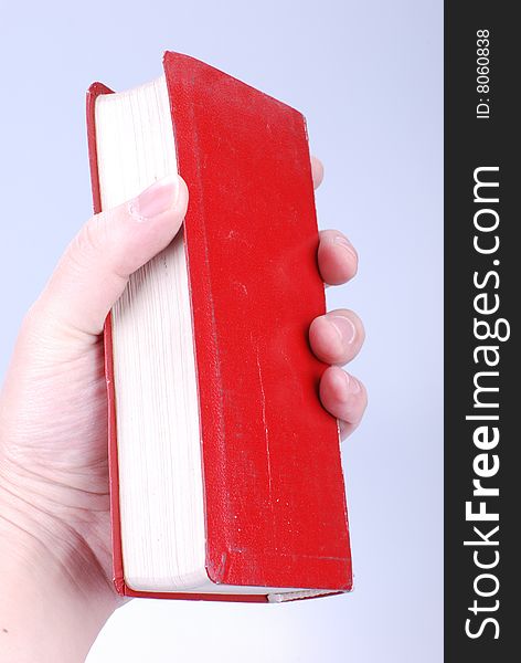 Simple red hardcover book in hand. Simple red hardcover book in hand