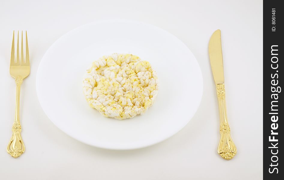 Rice cake on a plate with fork and knife.