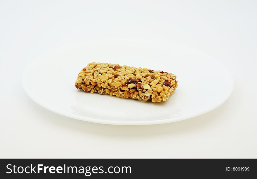 Energy bar on a plain white dish.  Great for quick boost of much needed nutrition.
