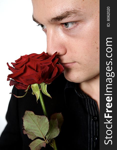 Man holding a rose on a with background close up. Man holding a rose on a with background close up