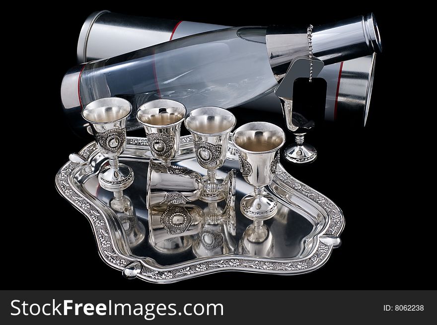 Bottle of vodka and set of silver wine-glasses on a tray. Bottle of vodka and set of silver wine-glasses on a tray.