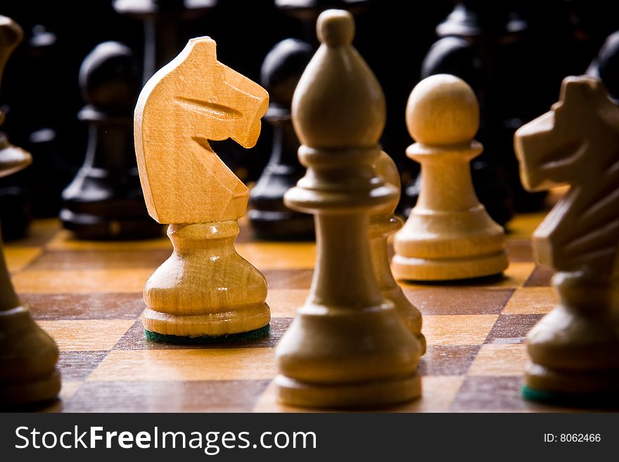 Old Craved wooden Chess pieces on a Board