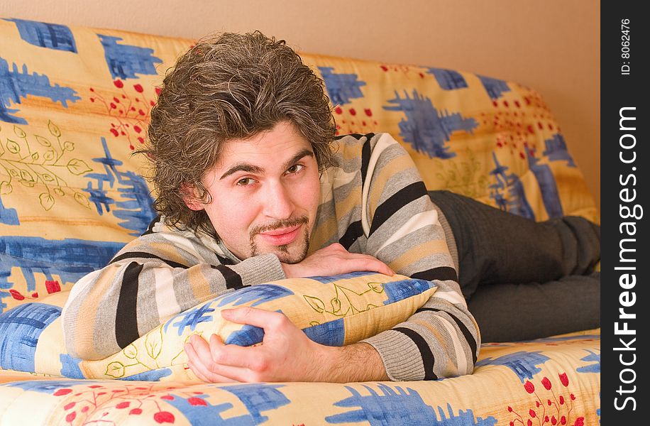 Young handsome male on colourful sofa