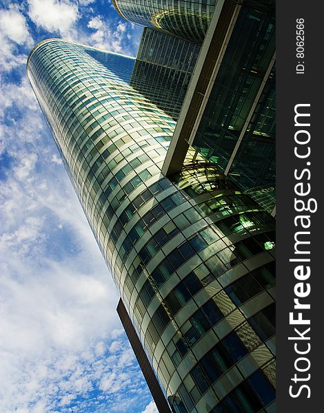 Modern skyscraper under cloudy blue sky