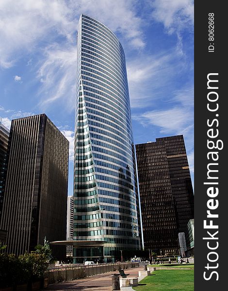 Modern skyscraper under cloudy blue sky