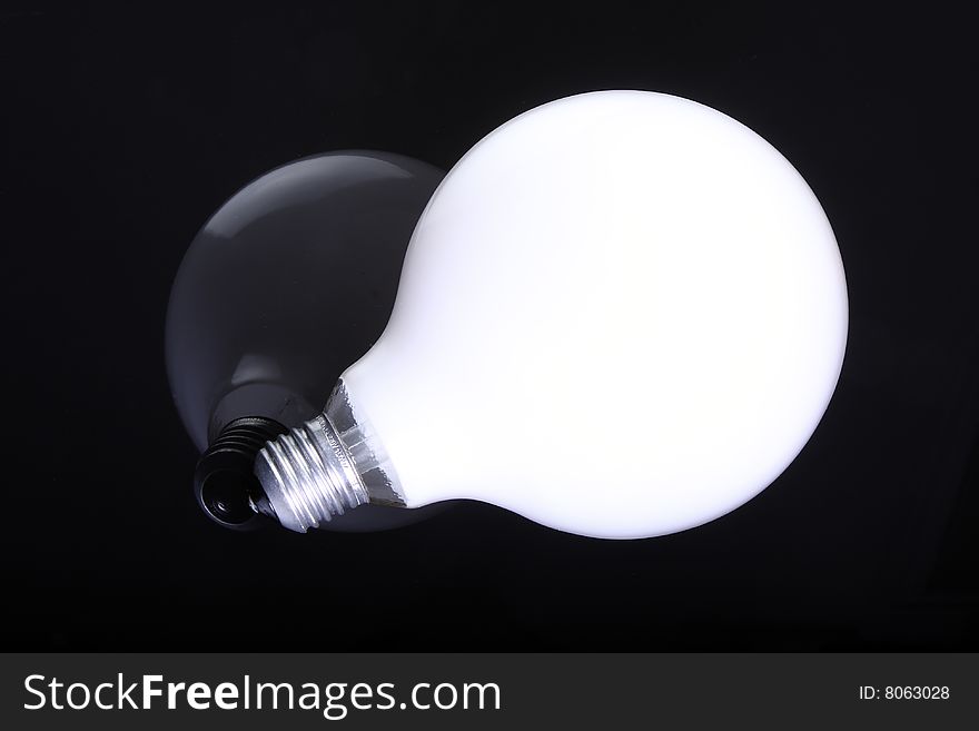 Light bulb on a black background with reflection. Light bulb on a black background with reflection