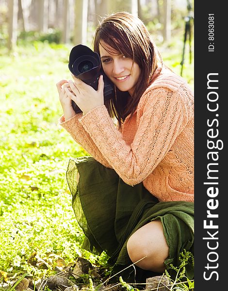 Young pretty female photographer in a forest.