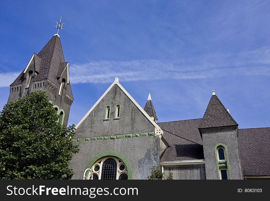 Old Grey Stucco Church against partly cloudy sky. Old Grey Stucco Church against partly cloudy sky