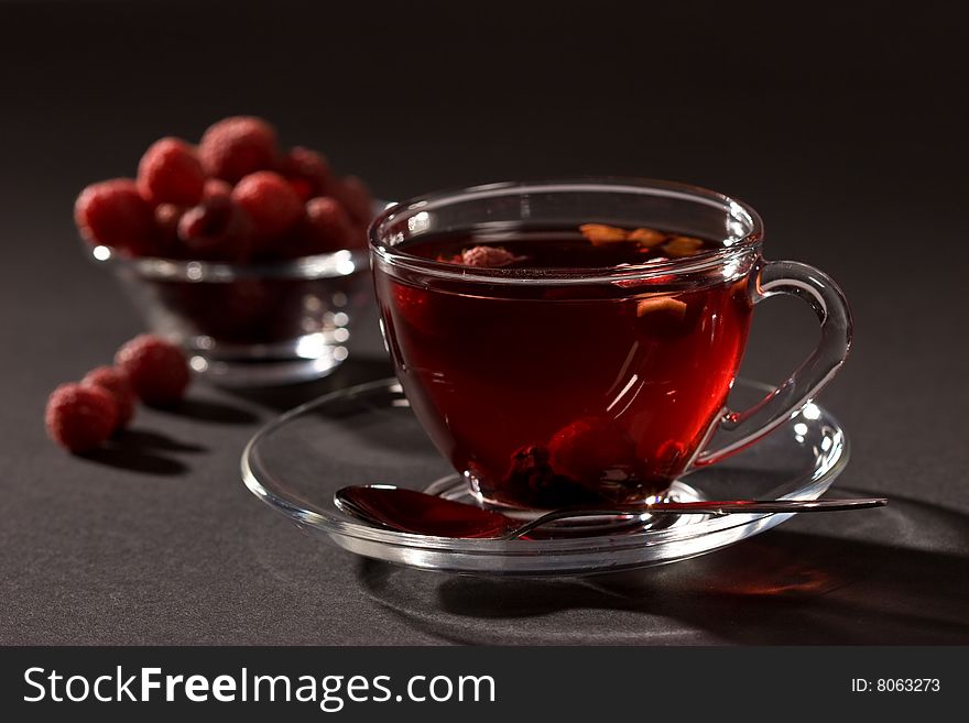 Cup of tea with raspberry syrup and some raspberries. Cup of tea with raspberry syrup and some raspberries