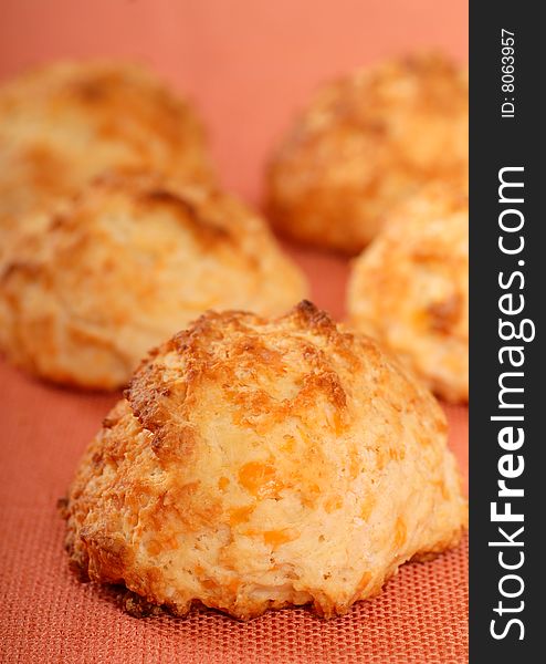 Freshly baked cheddar cheese biscuits cooling on a cloth