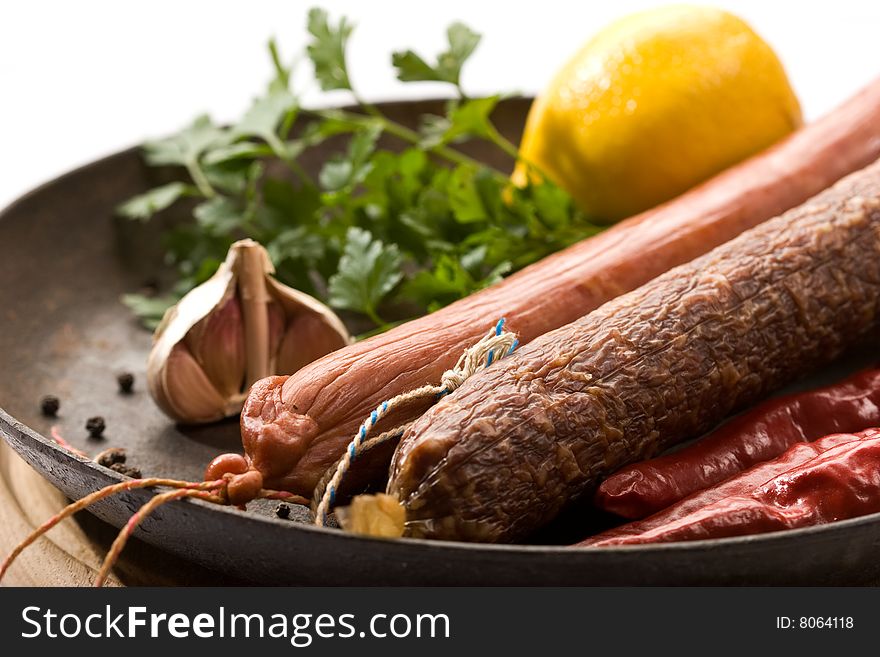 Tasty still life: appetizing smoked sausage and pepper wiht parsley