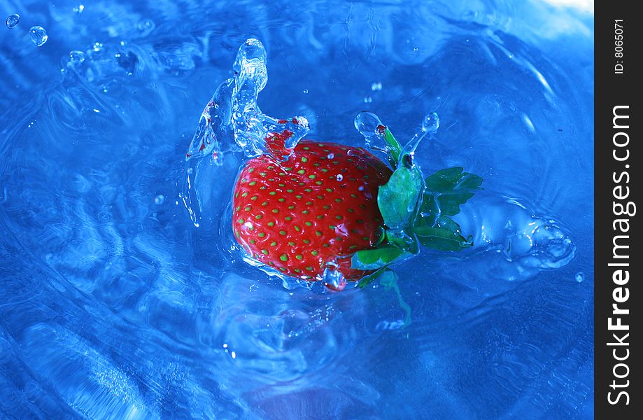 Fresh strawberries splashing into cold water, white balance deliberately set to custom to create feeling of cold and fresh. Fresh strawberries splashing into cold water, white balance deliberately set to custom to create feeling of cold and fresh.