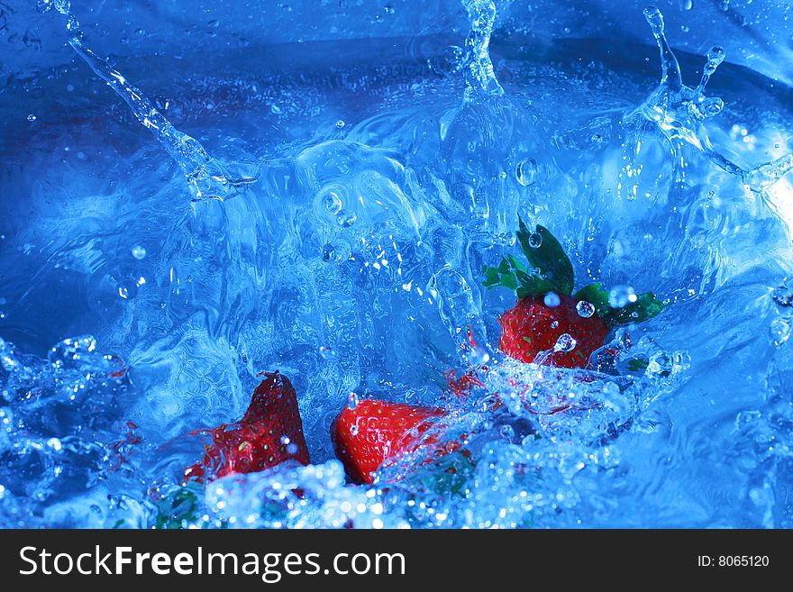 Fresh strawberries splashing into cold water, white balance deliberately set to custom to create feeling of cold and fresh. Fresh strawberries splashing into cold water, white balance deliberately set to custom to create feeling of cold and fresh.