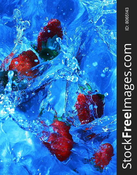 Fresh strawberries splashing into cold water, white balance deliberately set to custom to create feeling of cold and fresh.