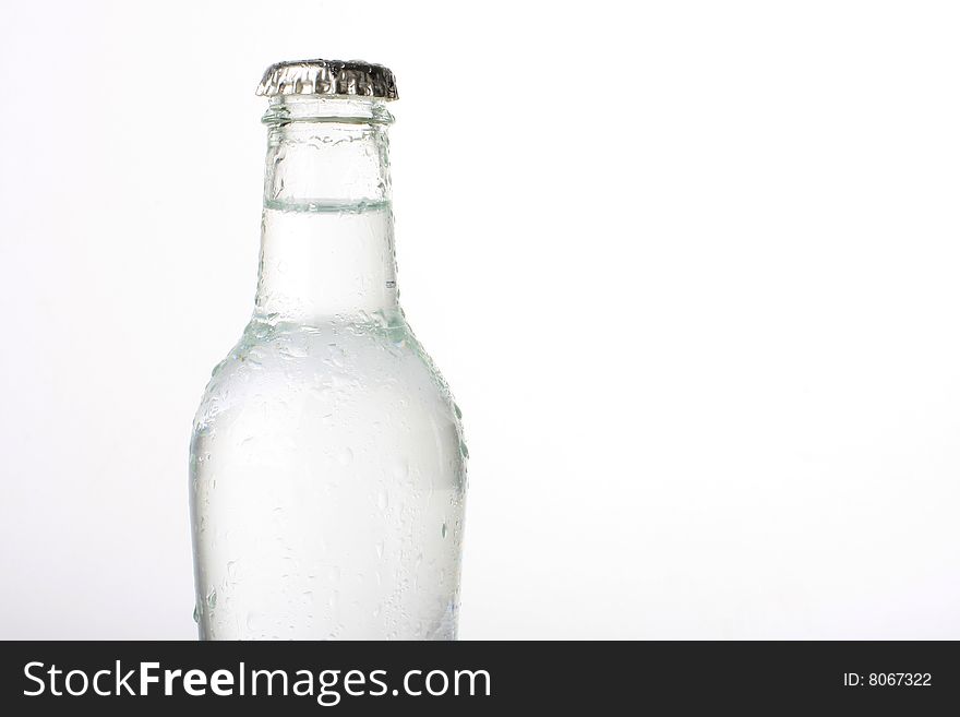 Bottled water with water drops, isolated on white with copy space. Bottled water with water drops, isolated on white with copy space