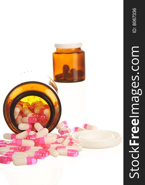 Medicine spilling out of pill bottles, isolated on white with high key lighting. Medicine spilling out of pill bottles, isolated on white with high key lighting