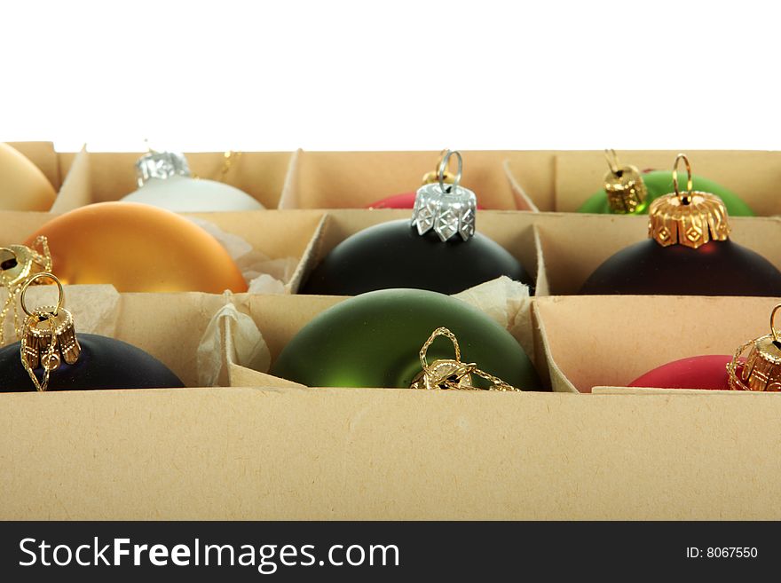 Paper box filled with multi colored christmas ornaments, copy space, shot on white. Paper box filled with multi colored christmas ornaments, copy space, shot on white