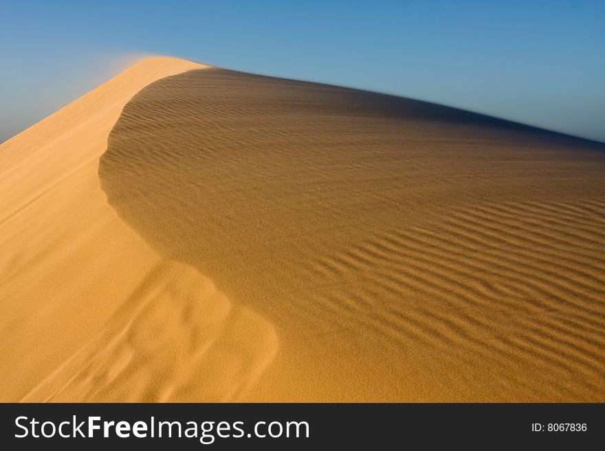 Stockton sand dunes in Anna Bay, NSW, Australia. Sand ripples detail with dramatic shadows. Taken in low light conditions.