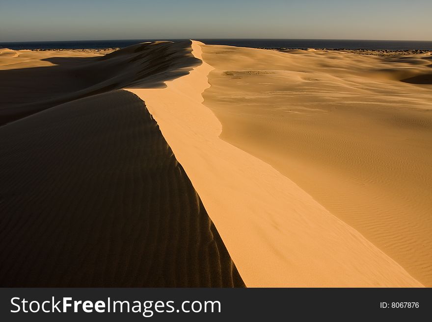 Stockton sand dunes in Anna Bay, NSW, Australia. Sand ripples detail with dramatic shadows. Taken in low light conditions.