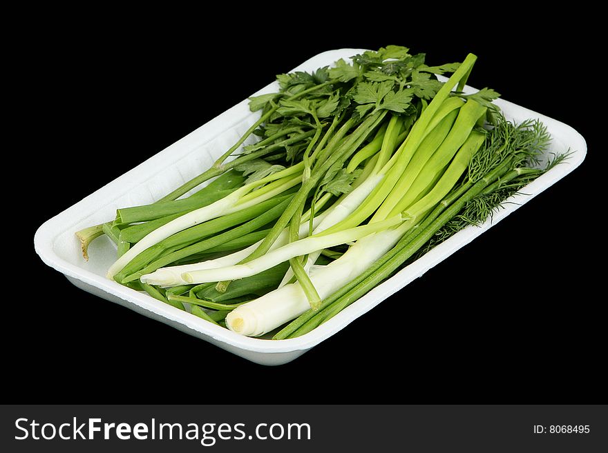 Vegetables in the plastic container on a black background