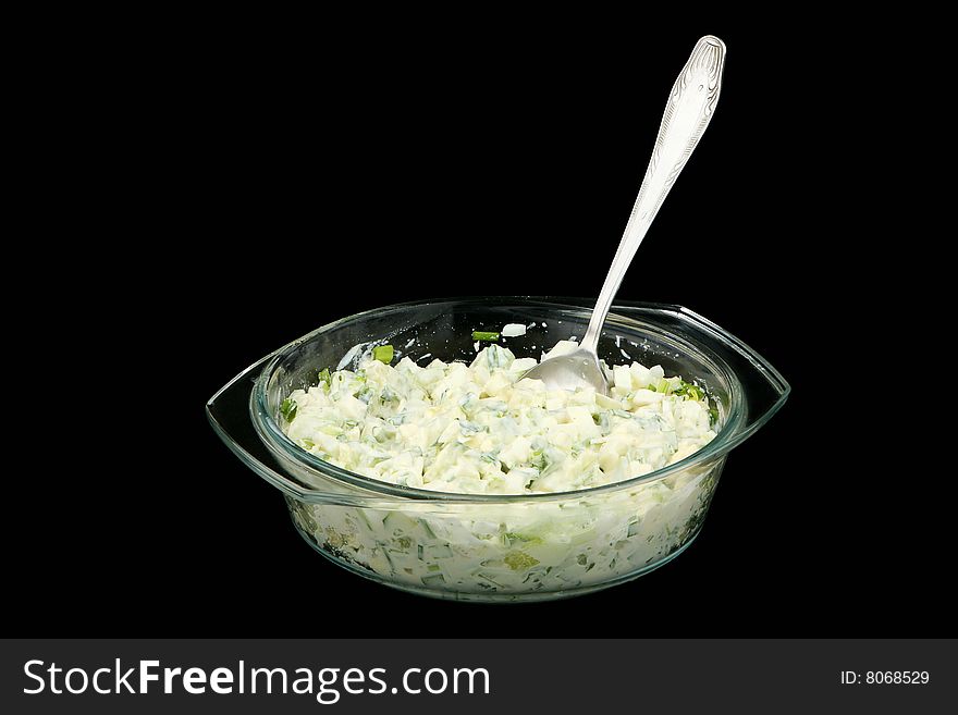 Vegetable salad in a glass plate on a black background