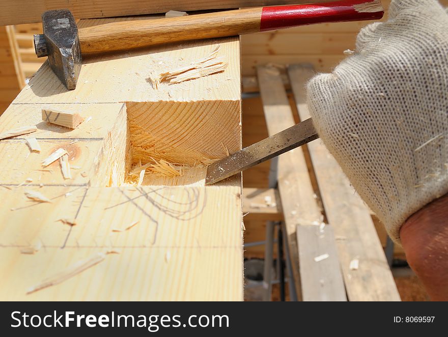 The carpenter makes dredging in a wooden wall. The carpenter makes dredging in a wooden wall.