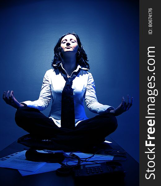 An attractive businesswoman in lotus position, invoking good karma over the business. An attractive businesswoman in lotus position, invoking good karma over the business.