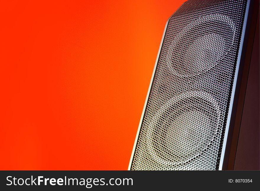 A compact loudspeaker & orange background. A compact loudspeaker & orange background
