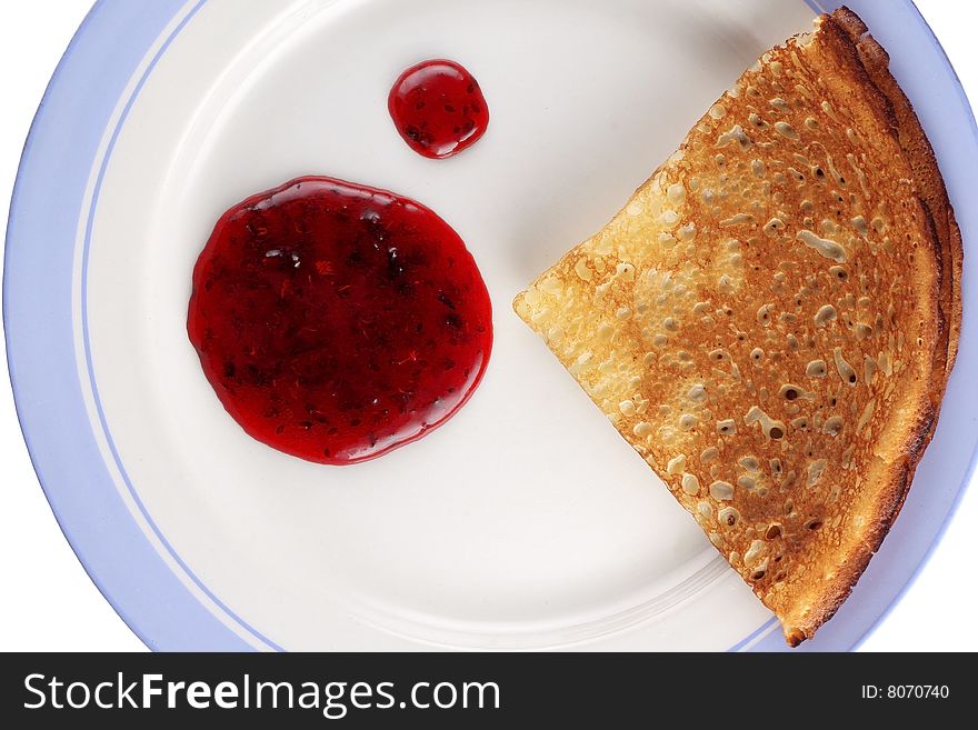 Pancake with red jam on dish