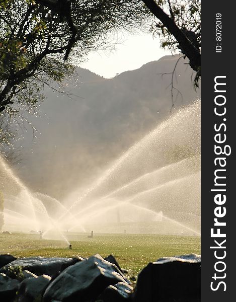 A view of a golf fairway being watered