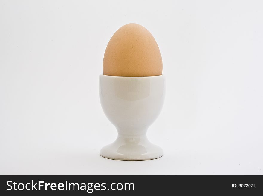 Egg in ceramic eggcup on a white background