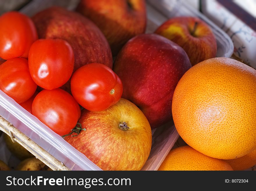 Tomatoes with red apples and oranges. Shallow depth of field. Tomatoes with red apples and oranges. Shallow depth of field