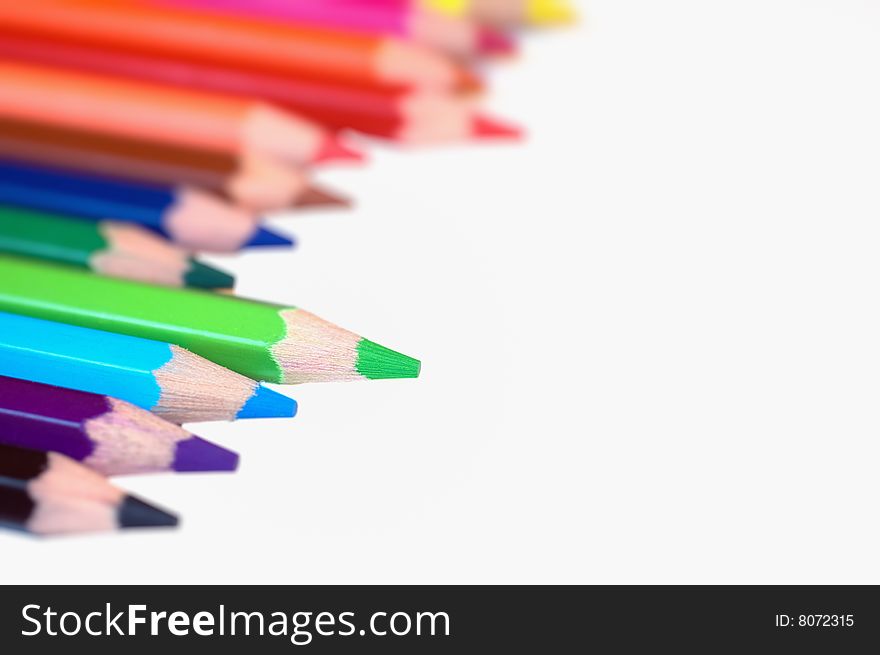 Coloring pencils isolated on white. Shallow depth of filed. Focus on green pencil