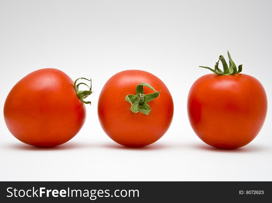 Three tomatoes on the white background.