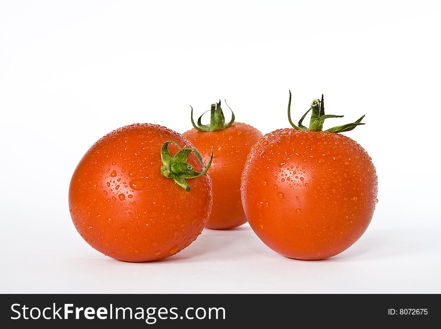 Three tomatoes on the white background.