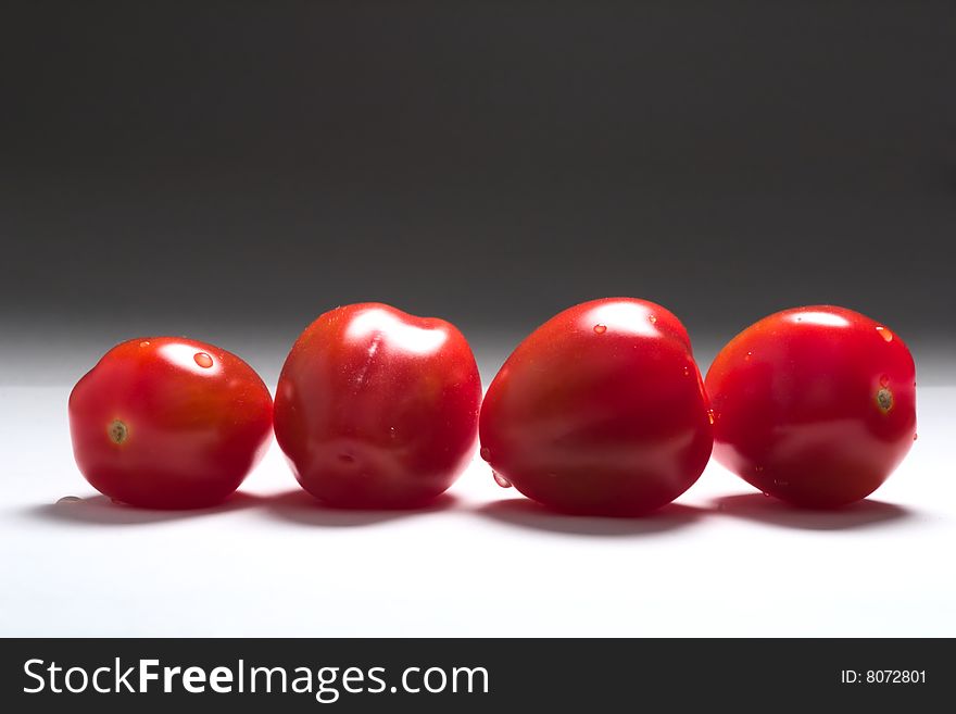 Four small tomatoes (red, white and grey  colors). Four small tomatoes (red, white and grey  colors)