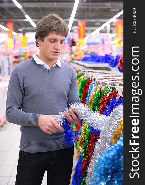 Young man chooses Christmas-tree decoration