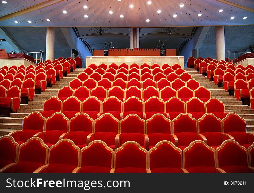 Empty auditorium with red chairs