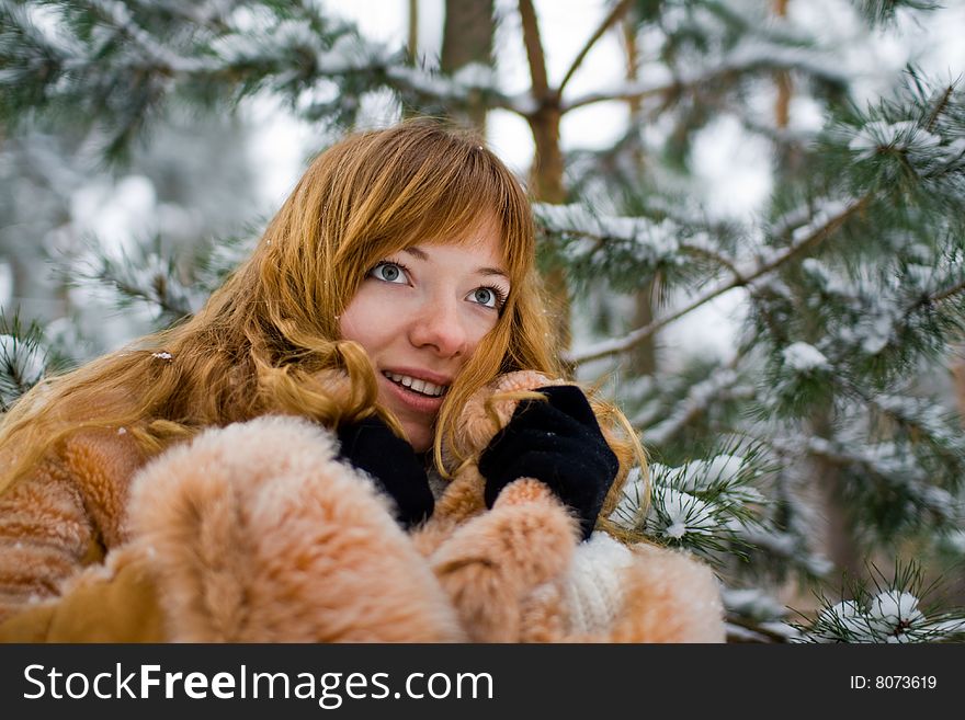 Red-heared girl in fur coat outdoors - shallow DOF. Red-heared girl in fur coat outdoors - shallow DOF