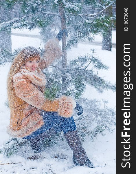 Red-heared girl in short fur coat outdoors - shallow DOF. Red-heared girl in short fur coat outdoors - shallow DOF