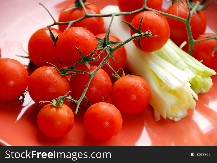 Appetizing red cherry tomatoes closeup on red plate. Appetizing red cherry tomatoes closeup on red plate